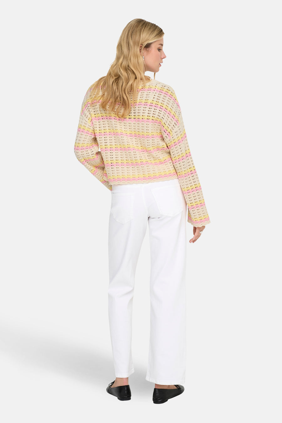Pull à col rond multicolore de ONLY, porté avec un jean blanc et des ballerines noires.
