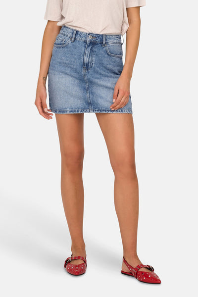 Jupe courte en denim bleu clair de ONLY, avec une coupe droite et des chaussures rouges à ornements.
