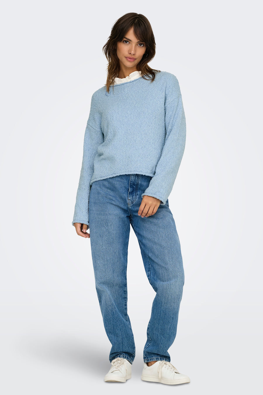 Pull bleu à col rond de ONLY, porté avec un jean ample et des baskets blanches.
