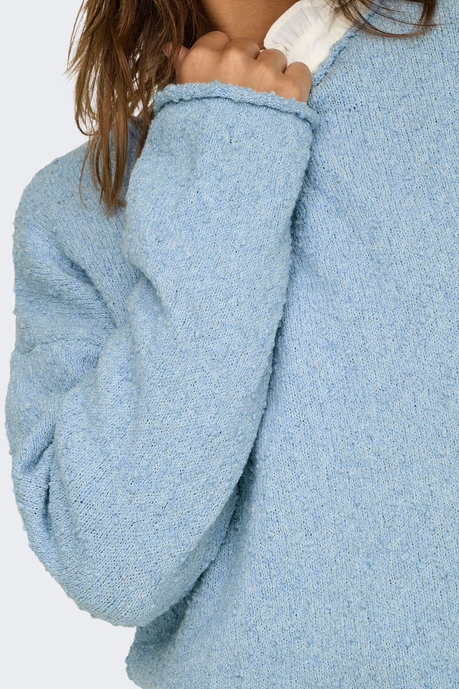 Blauwe trui met ronde hals van ONLY, zachte gebreide textuur, zichtbaar wit detail bij de hals.