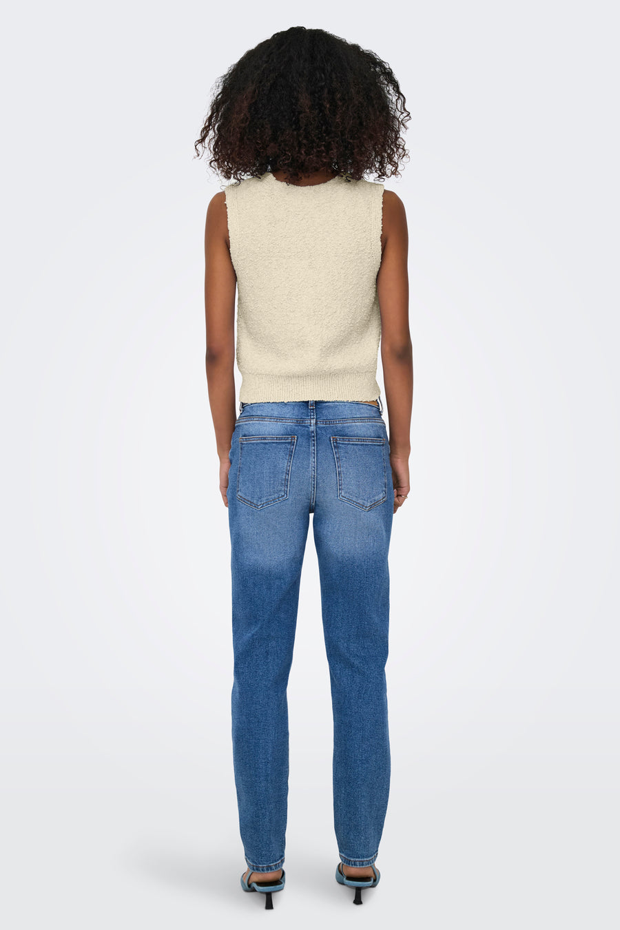 Débardeur écru par ONLY®, porté avec un jean bleu délavé et des talons aiguilles bleus, vue de dos.
