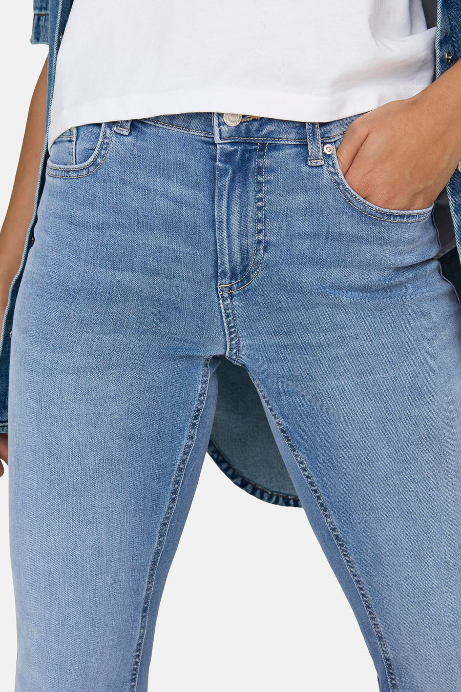 Jean évasé bleu moyen de ONLY, avec une main dans la poche et une veste en jean visible.
