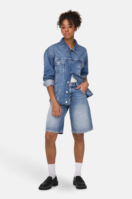 Short en jean bleu moyen de ONLY, porté avec une veste en jean, des chaussettes blanches et des mocassins noirs.
