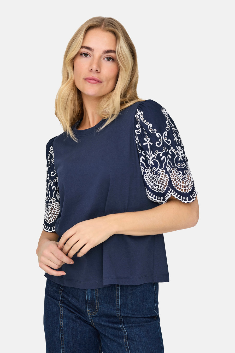 T-shirt bleu à manches courtes de JDY avec détail de broderie florale blanche sur les manches.