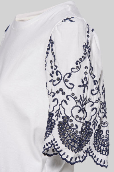 T-shirt blanc à manches courtes de JDY, avec broderies florales bleues sur les manches.
