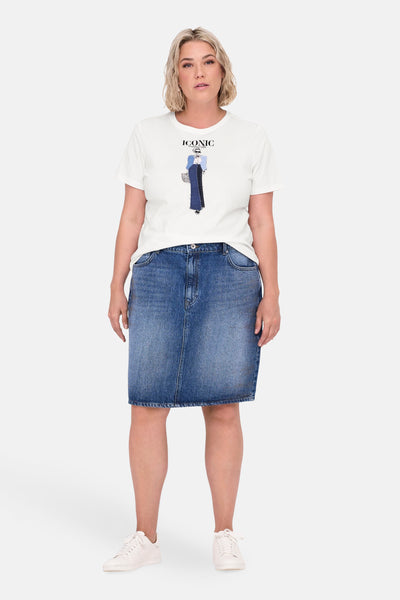 Wit T-shirt met korte mouwen van CARMAKOMA met opdruk, gedragen met een blauwe spijkerrok en witte schoenen.