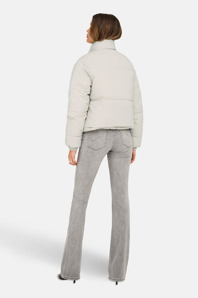 Veste courte beige de JDY, vue de dos, portée avec un jean gris évasé et des talons aiguilles.