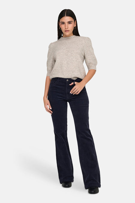 Pull col rond gris de JDY, agrémenté de perles décoratives, porté avec un pantalon en velours côtelé.