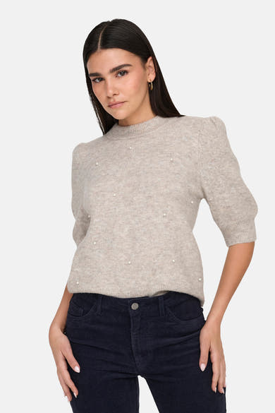 Pull col rond gris de JDY orné de perles, porté avec un pantalon en velours côtelé.
