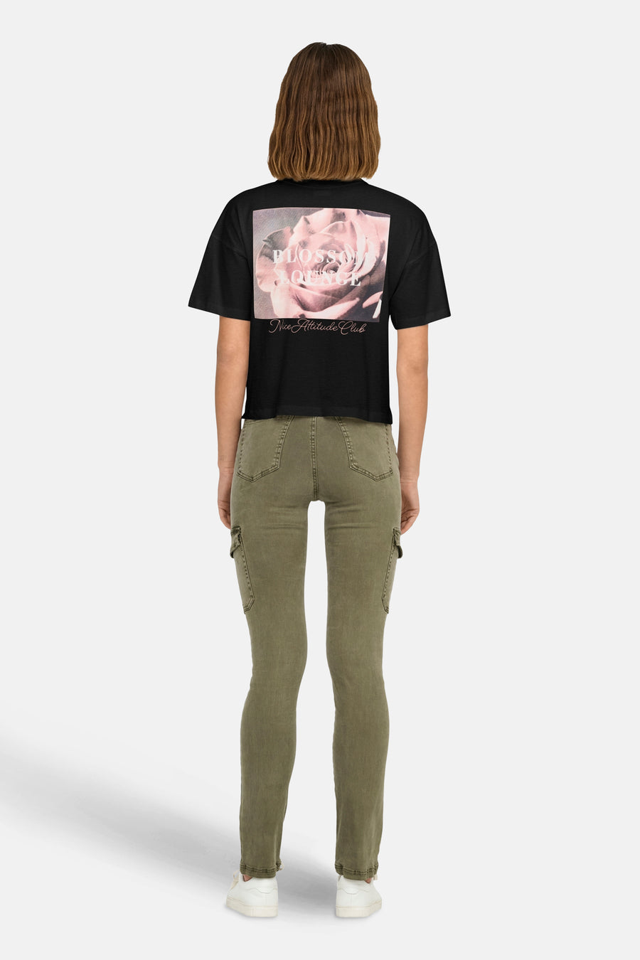 Zwart T-shirt van JDY met bloemenprint op de rug, gedragen met een olijfgroene cargobroek en witte sneakers.