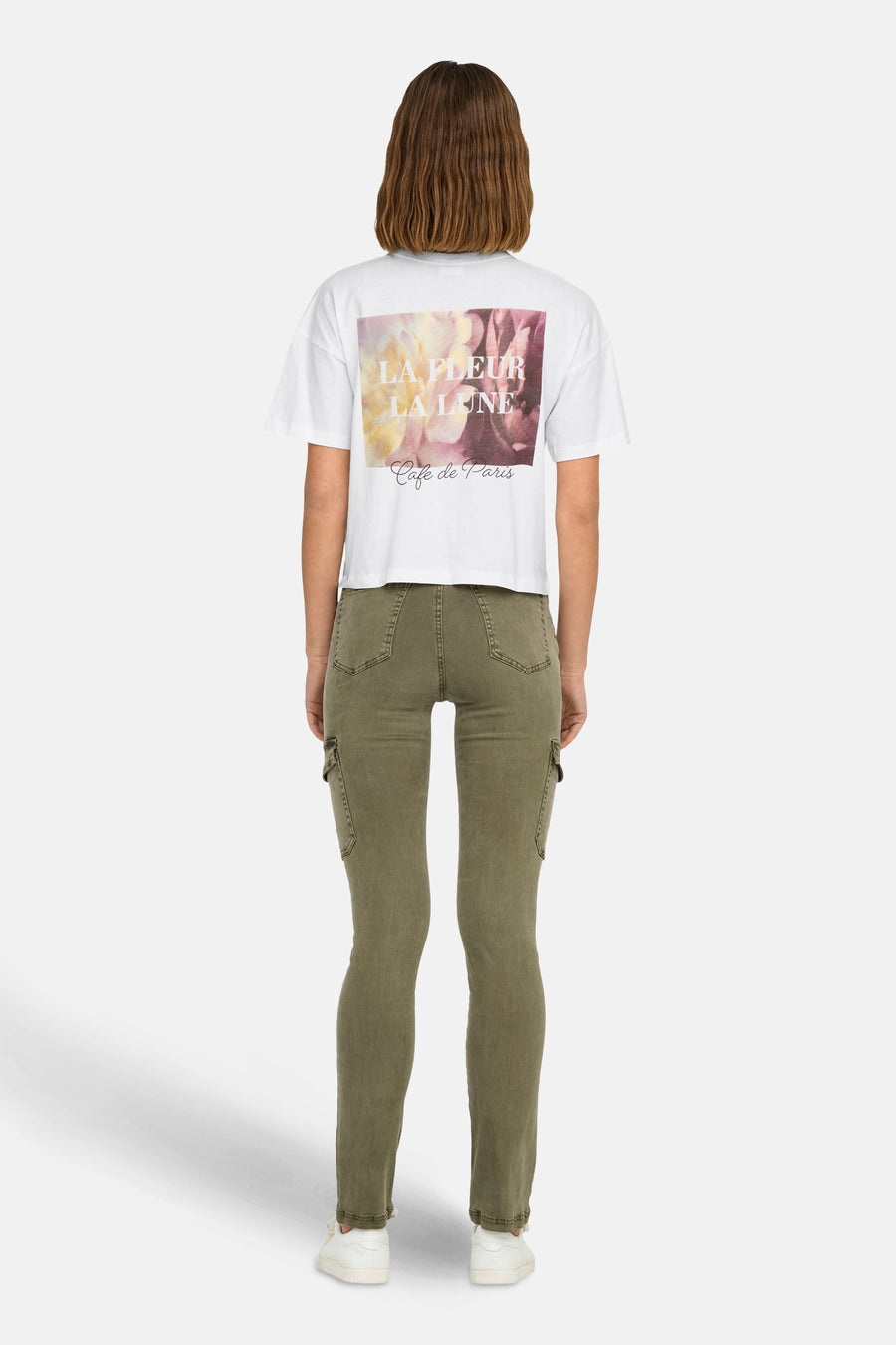Wit T-shirt van JDY met bloemenprint en "Café de Paris" opschrift op de rug, gedragen met een olijfgroene cargobroek.