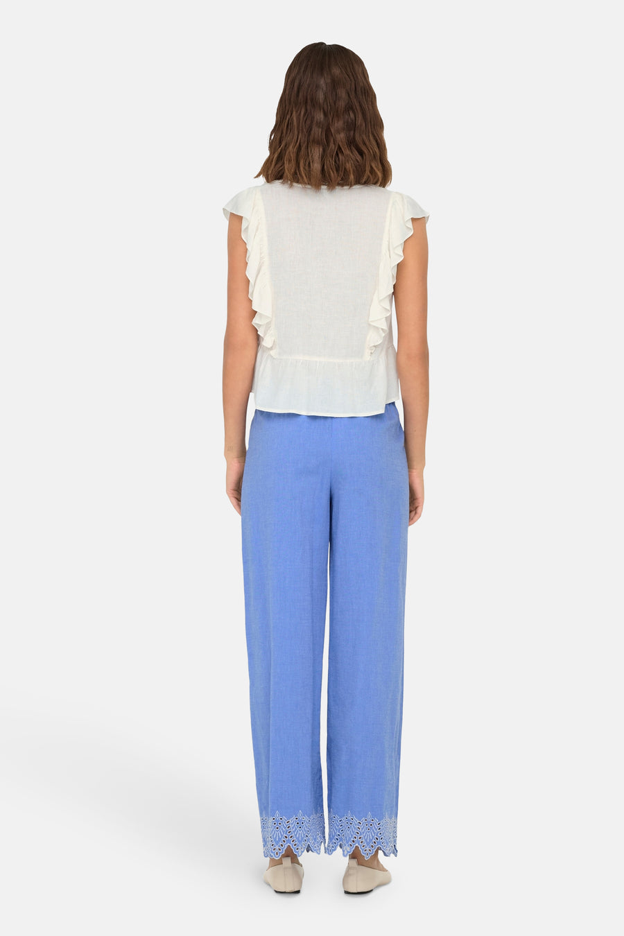 Blauwe broek van ONLY, met geborduurde kanten rand, gedragen met een witte top met ruches.