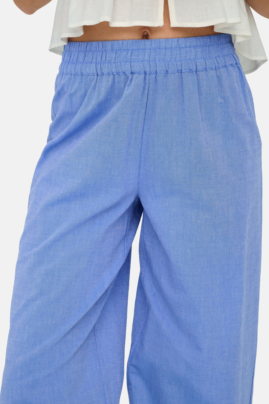 Lichtblauwe broek van ONLY®, met wijde pijpen en elastische taille, gedragen met een witte top.