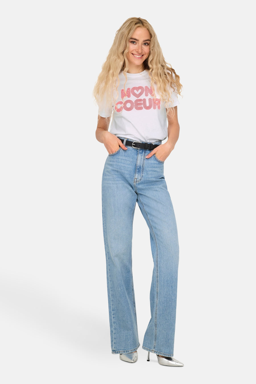 Wit T-shirt met korte mouwen van ONLY, gedragen met een high-waisted jeans en zilveren schoenen.