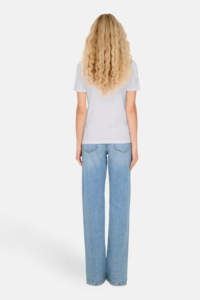 Wit T-shirt met korte mouwen van ONLY, gedragen met een wijde blauwe spijkerbroek, van achteren gezien.