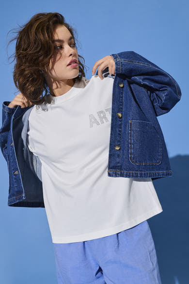 Wit T-shirt met korte mouwen van ONLY, met het decoratieve woord 'ART', gedragen met een spijkerjasje en een blauwe broek.