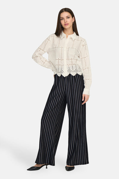 Zwarte en witte gestreepte broek van ONLY, gedragen met een doorzichtige blanke hemd.