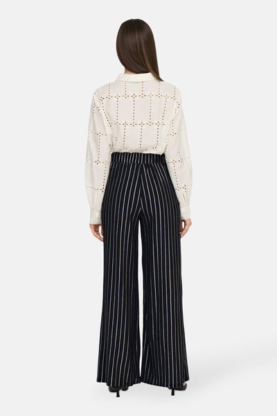 Zwarte gestreepte broek door ONLY®, gedragen met een doorboord witte blouse, rugweergave.