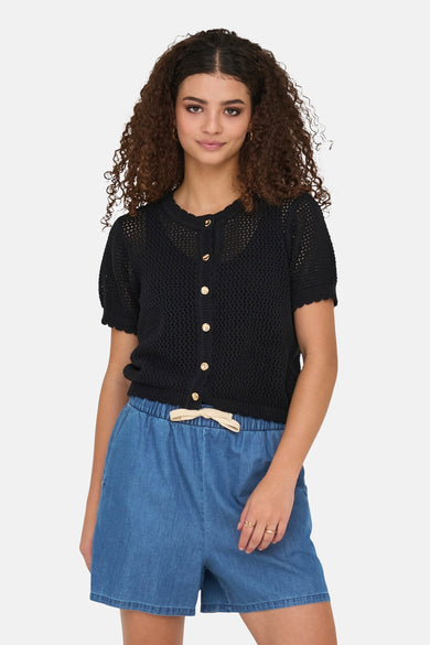 Zwart gilet van ONLY, met gouden knopen, gedragen met een blauwe spijkerbroek en ringen.
