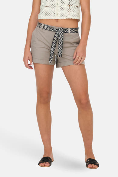Short beige de ONLY®, avec une ceinture à motifs géométriques, porté avec un haut en crochet.