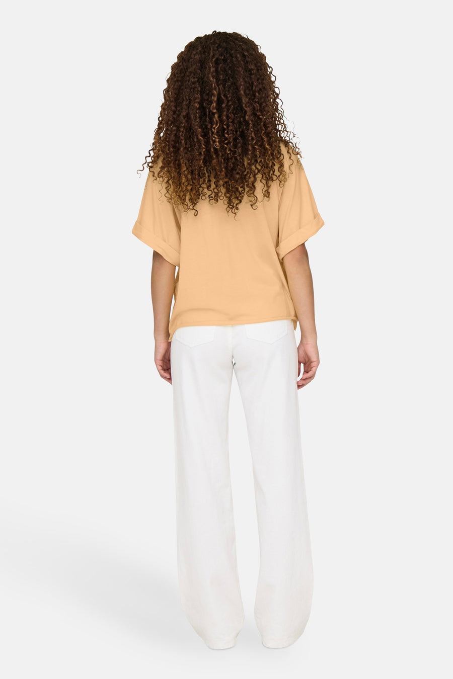 Oranje T-shirt met korte mouwen van ONLY®, gedragen met een witte broek met hoge taille, achtergezicht.