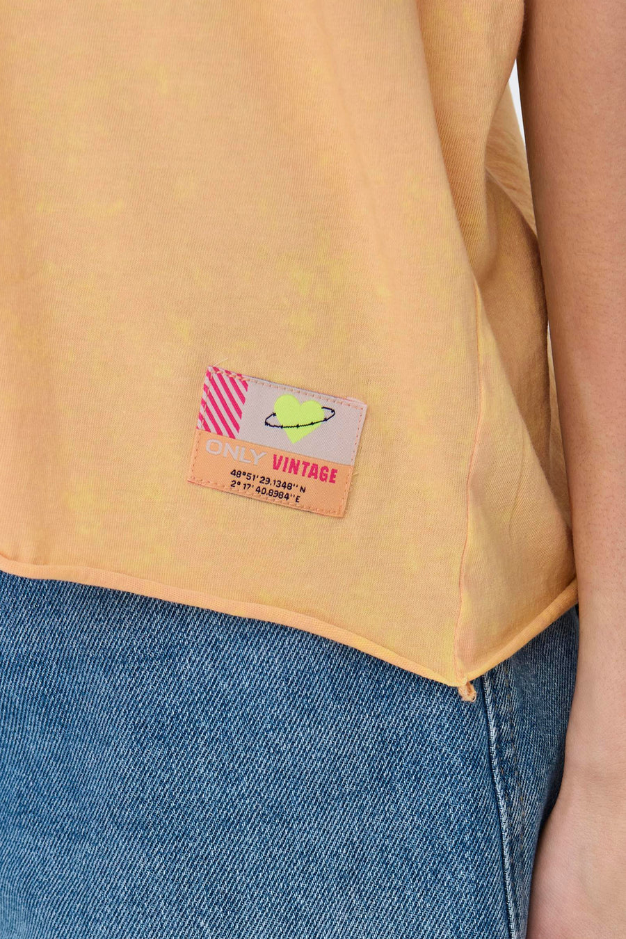 Oranje T-shirt met korte mouwen van ONLY, met een decoratieve patch met strepen en GPS-coördinaten, gedragen met een spijkerbroek