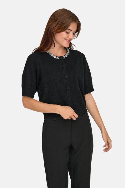 Gilet noir by JDY, avec col orné de pierres brillantes, porté sur un pantalon noir uni.

