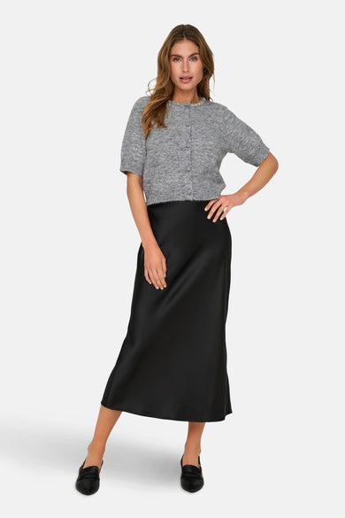 Gemêleerd grijs vest van JDY, gedragen met een zwarte satijnen rok en loafers.