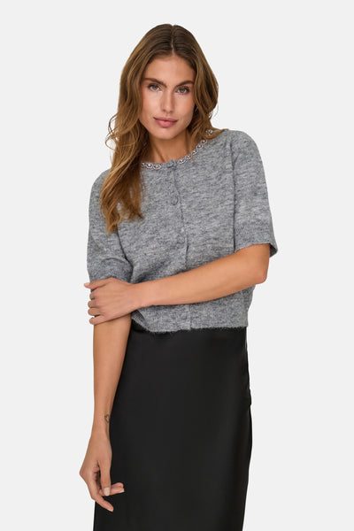 Grijze gebreide bodywarmer van JDY, met sierlijke bies rond de halslijn en gedragen met een zwarte rok.