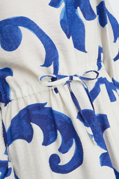 Blauwe jurk met lange mouwen van JDY, blauw-wit bloemenpatroon, met een strikceintuur in de taille.