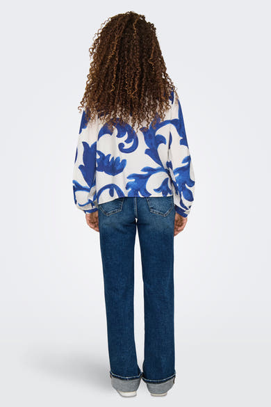 Blauwe blouse met lange mouwen van JDY, met een bloemenpatroon, gedragen met een blauwe jeans en grijze schoenen.