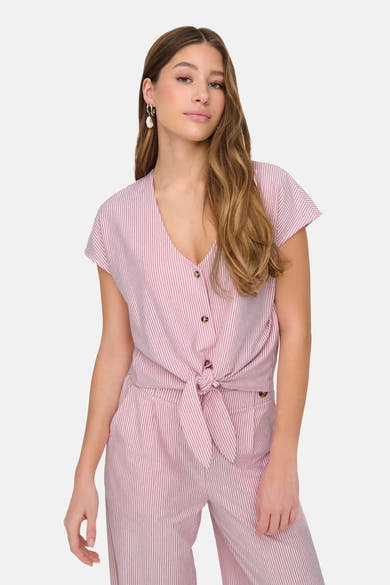 Chemisier rose à rayures verticales de JDY, noué à la taille, porté avec des boucles d'oreilles pendantes.
