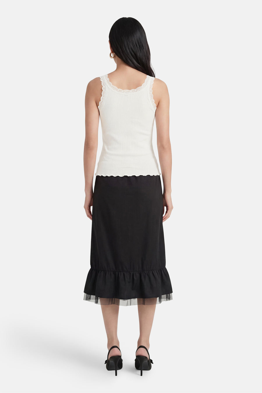 Top blanc côtelé de ONLY® avec bordure en dentelle, ourlet festonné, vue de dos. Porté avec une jupe noire.