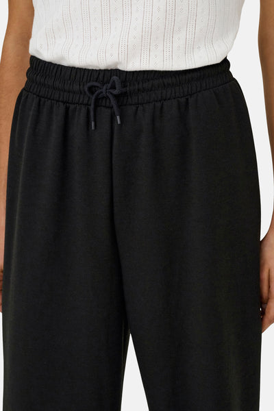 Zwarte joggingbroek van ONLY met trekkoord in de taille, gedragen met een witte top.
