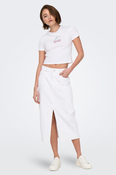T-shirt blanc à manches courtes de ONLY, orné d'un motif de cerises, porté avec une jupe blanche et des baskets.
