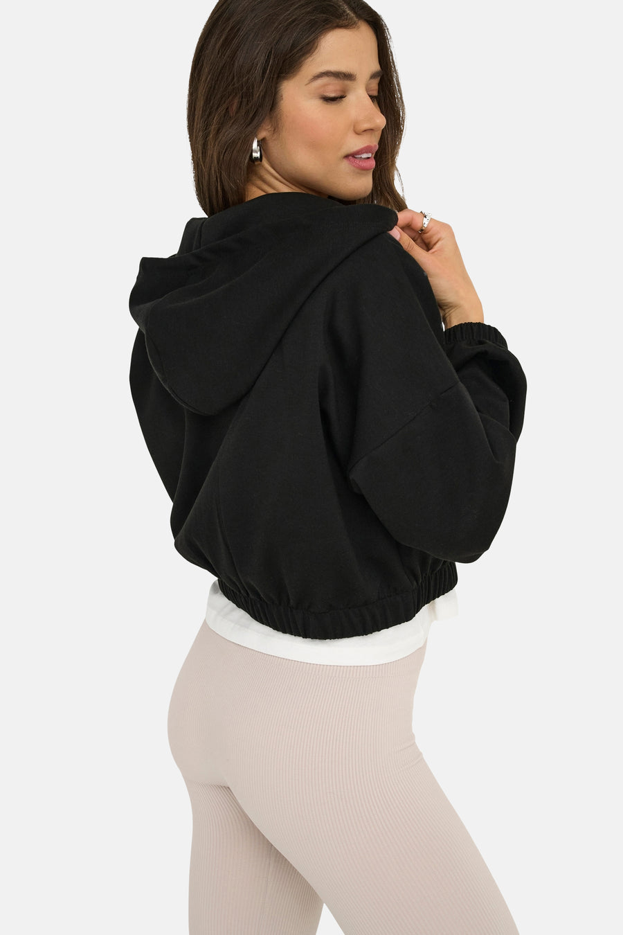 Zwarte gewatteerde bodywarmer met capuchon van ONLY®, gedragen met een wit T-shirt en een geribbelde legging.