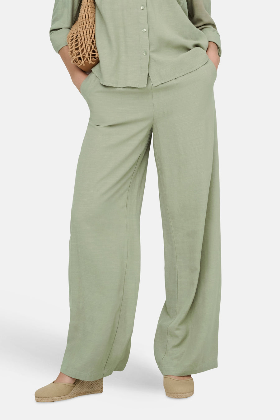 Pantalon ample vert de JDY, avec une texture légèrement froissée et des chaussures compensées beiges.
