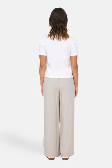 Wit T-shirt met korte mouwen van ONLY, gedragen met een wijde beige broek.