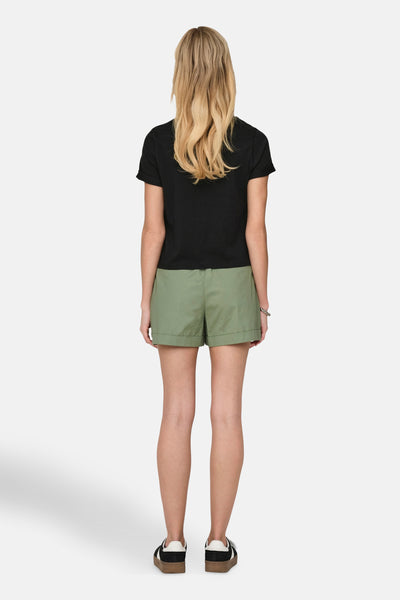 Zwarte t-shirt met korte mouwen van ONLY, gedragen met een groene broek en bicolore schoenen.