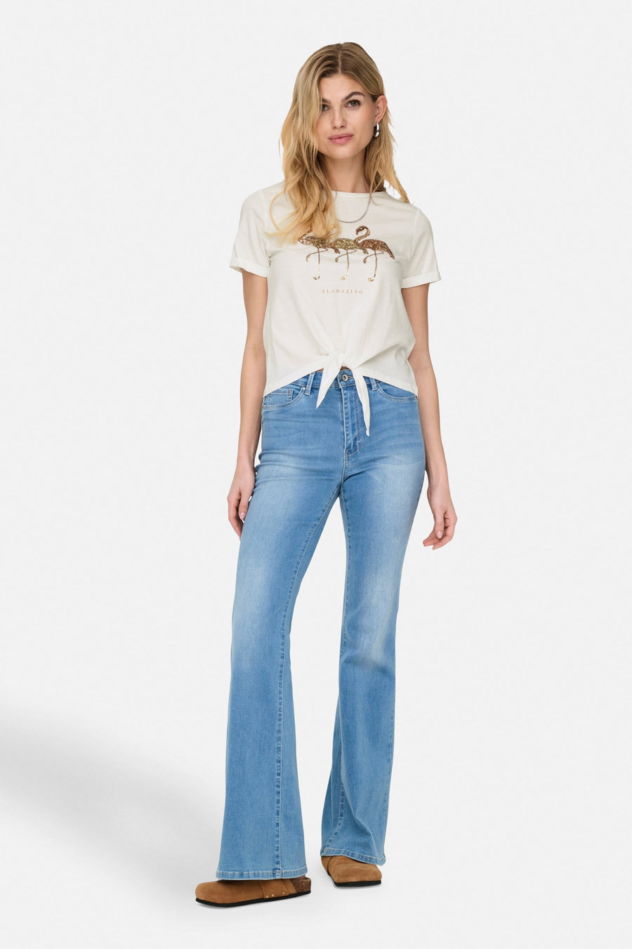 Wit T-shirt met korte mouwen van ONLY, met glitterende flamingo-print en een strik aan de voorkant, gedragen met een uitlopende jeans.