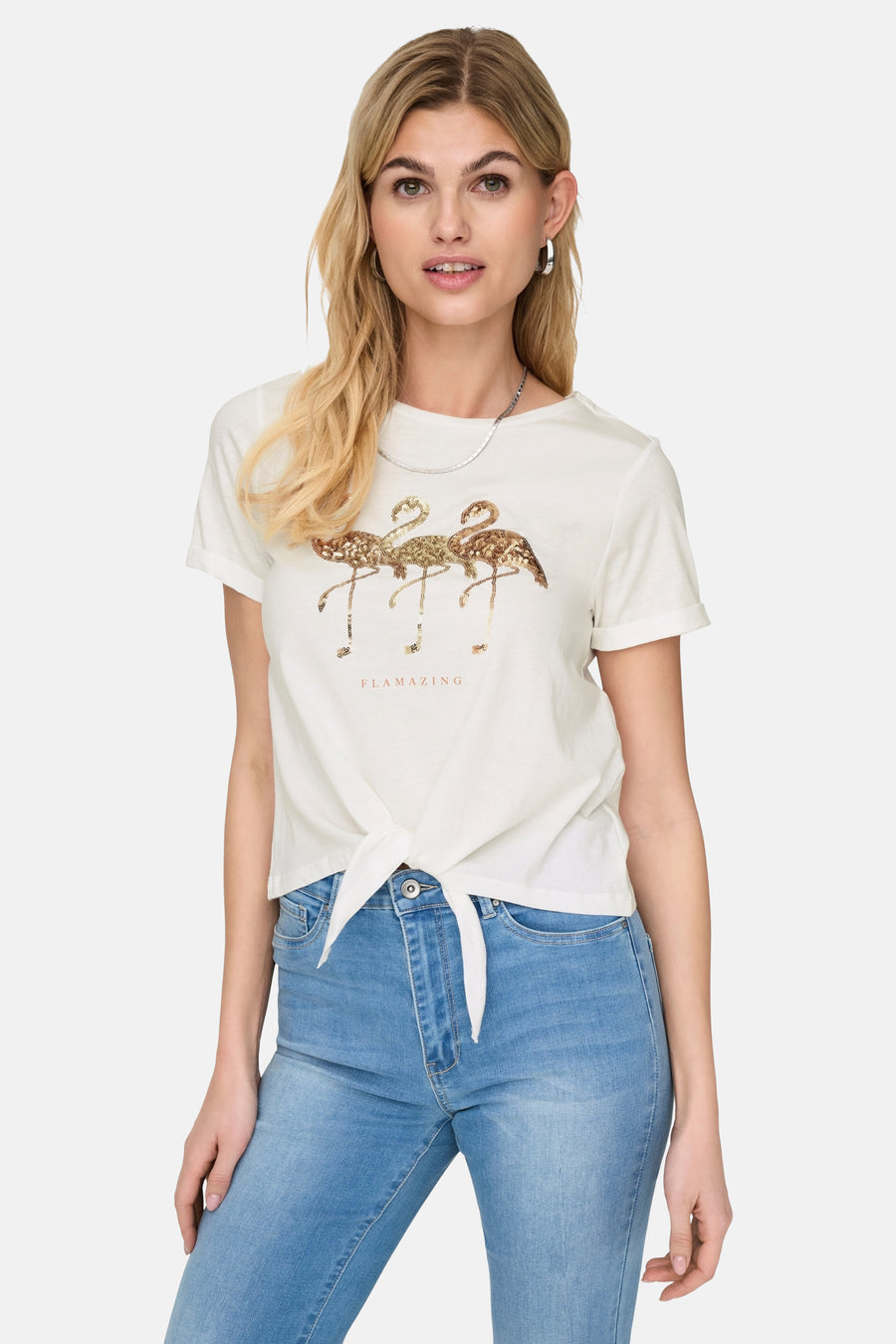 Wit T-shirt met korte mouwen van ONLY®, met glitterende flamingo-print en strik aan de voorkant, gedragen met een spijkerbroek.