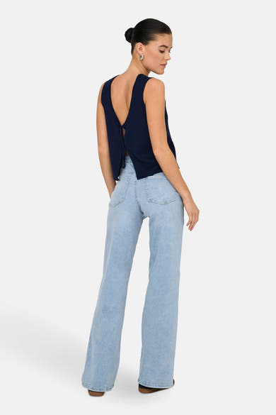 Lichtblauwe wijde jeans van JDY, gedragen met een marineblauw topje dat aan de achterkant is geknoopt.