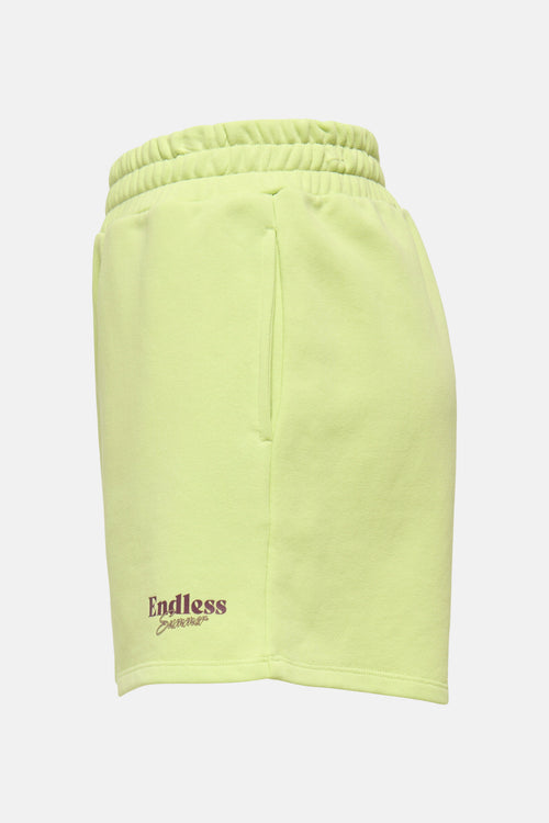 Short vert citron de ONLY® avec taille élastique, poches latérales et texte "Endless Summer" brodé en marron.