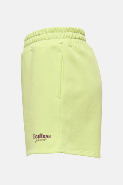 Short vert citron de ONLY® avec taille élastique, poches latérales et texte "Endless Summer" brodé en marron.