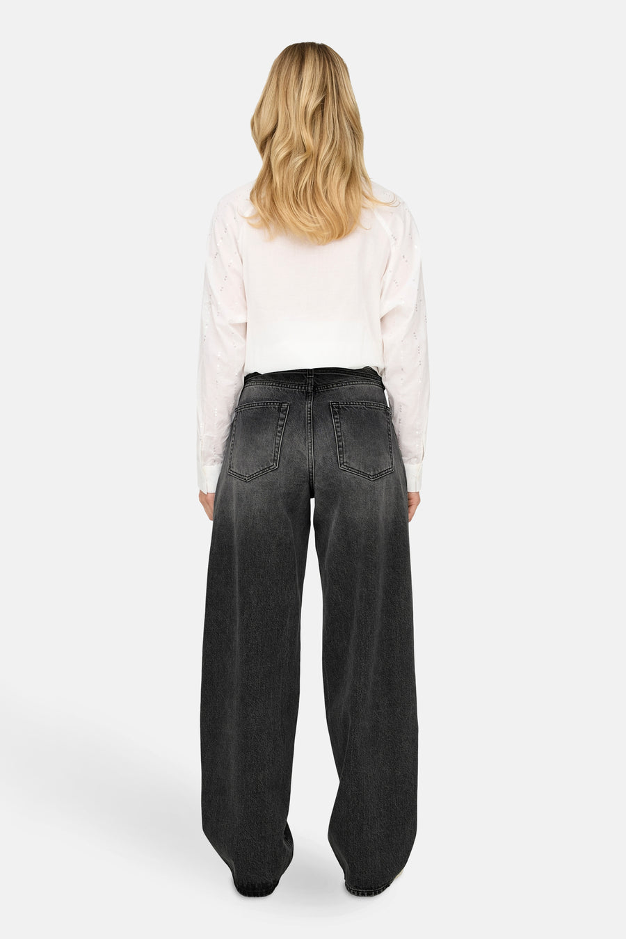 Jean droit en denim noir par ONLY, porté avec une chemise blanche à manches longues.