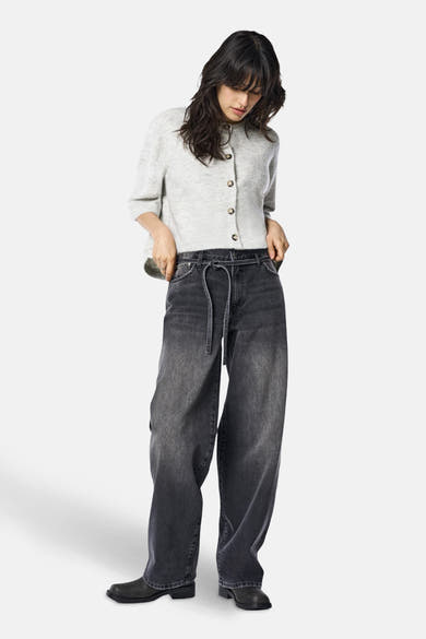 Jean droit en denim noir de ONLY®, avec une ceinture à nouer et des chaussures noires.
