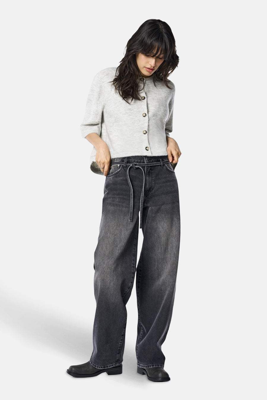 Jean droit en denim noir de ONLY®, avec une ceinture à nouer et des chaussures noires.
