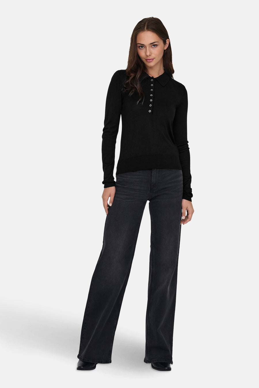Polo noir à manches longues de ONLY, porté avec un jean délavé ample et des chaussures noires.
