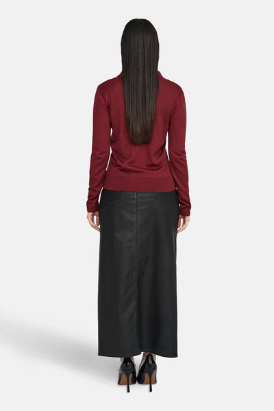 Polo à manches longues rouge de ONLY, porté avec une jupe longue noire et des chaussures à talons vernies, vue de dos.
