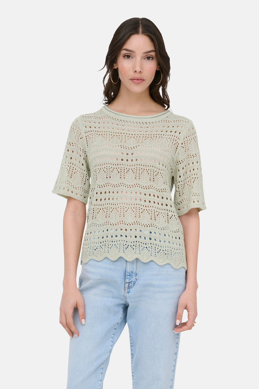 Pull à col rond vert par JDY, en maille ajourée à motifs décoratifs, porté avec un jean bleu clair.
